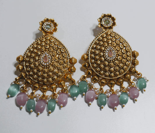 Gold earrings with green and pink stones on a white background