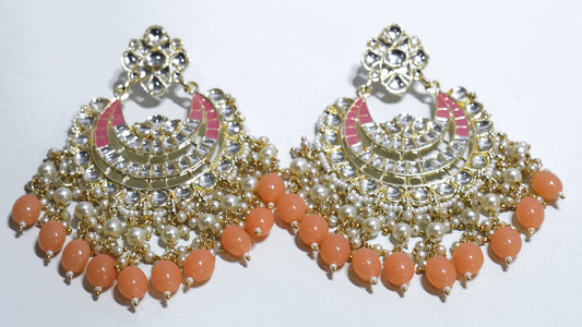 Ornate earrings with coral beads on a white background