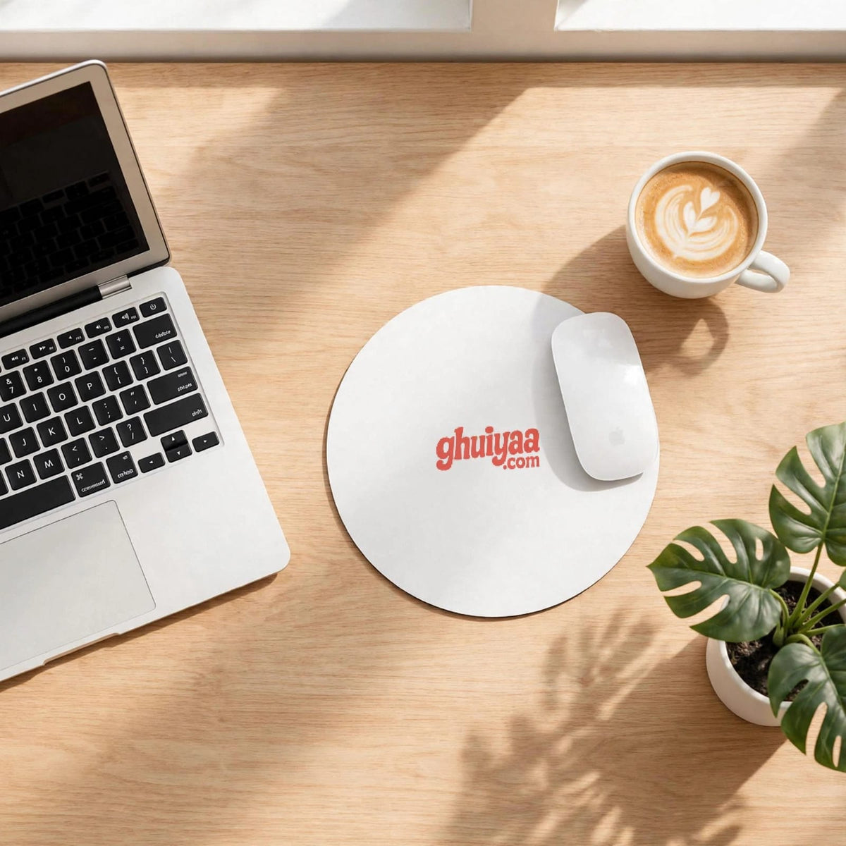 White circle mouse pad with Ghuiyaa.com logo on a minimal desk setup